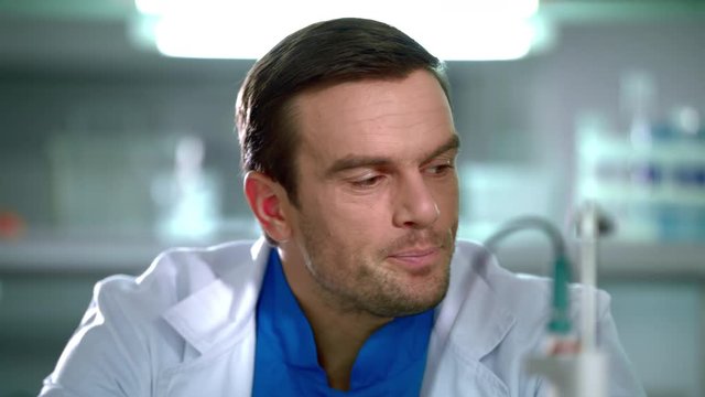 Man yawning. Closeup of doctor yawning in white coat. Portrait of doctor tired. Yawning man in laboratory. Tired scientist in lab. Tired doctor at work. Medical laboratory worker. Medical worker