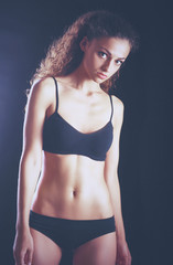 Portrait of young beautiful fitness woman, isolated on black background