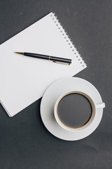 a notebook with a pen and a cup with a drink