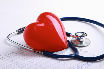 Red heart and a stethoscope on desk