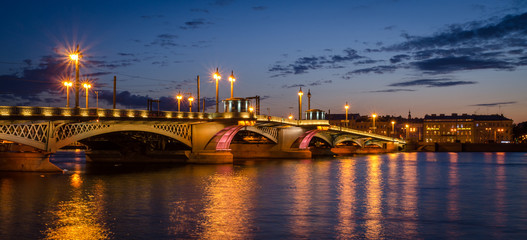 Night cityscape with river and bridge in Saint-Petersburg.