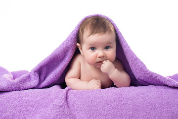 Newborn baby lying down and smiling in a purple towel