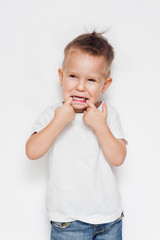 Cute young boy making a funny face against a white background 