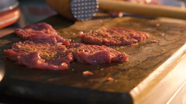 Close up of flavoring meat chops. Slow motion