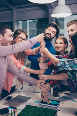 Happy businesspeople putting their fist on top of each other and