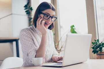 Happy pretty manager talking on mobile phone with client