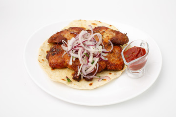 Fried chicken on pita bread with red sauce on a white background