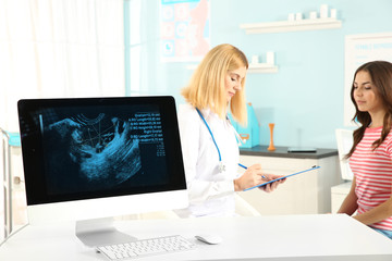 Computer with ultrasound scan with doctor and patient on background