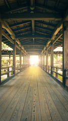 Wooden path through man made structure into the light