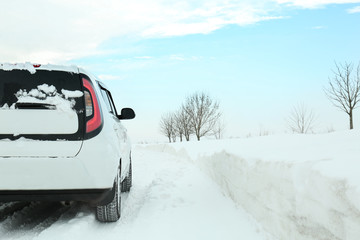 Back view of car driving on snowy winter road