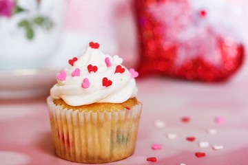 Valentine Cupcake topped with vanilla frosting and heart sprinkles