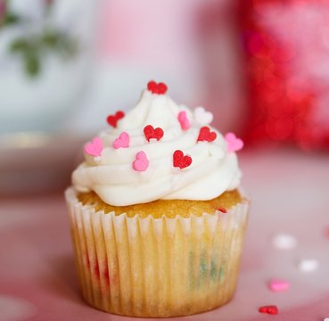 Valentine Cupcake topped with vanilla frosting and heart sprinkles