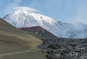 The active lava flow from a new crater on the slopes of volcanoes Tolbachik, on background...