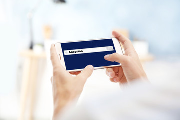 Adoption concept. Male hands with smartphone and search box on screen