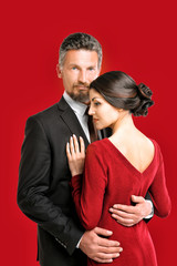 Mature elegant couple on color background