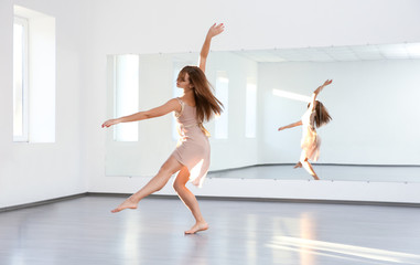 Beautiful young woman dancing in studio