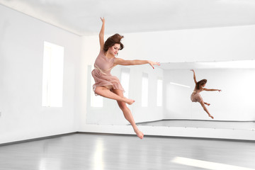 Naklejka premium Beautiful young woman dancing in studio