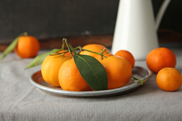 Plate with tangerines on table