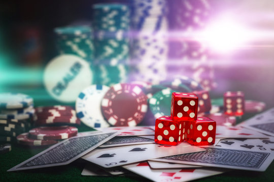 Poker Chips in casino gamble green table multi color lighting.