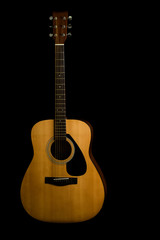 Obraz premium Acoustic guitar on a black background with copy space