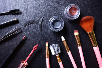 Makeup brushes set on black leather background