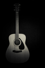 Fototapeta premium Acoustic guitar on a black background with copy space,black and white 