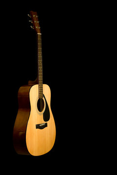 Acoustic guitar on a black background with copy space