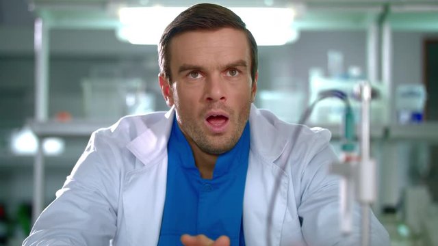 Tired scientist yawning in lab. Portrait of tired researcher yawning at laboratory. Yawning man in white coat. Tired worker in laboratory. Close up of scientist at lab. Research laboratory worker