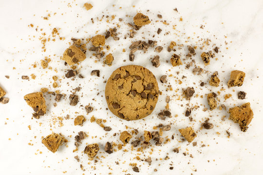 Chocolate chips cookie with crumbs on white marble