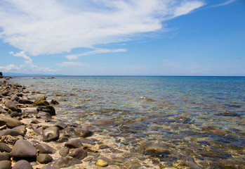 Sea and stones summer vacation travel photo. Tropic island stone beach in sunny day.