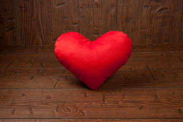 Red heart pillow on vintage wooden background