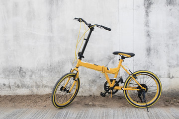 Fototapeta na wymiar Yellow bicycle on wall background