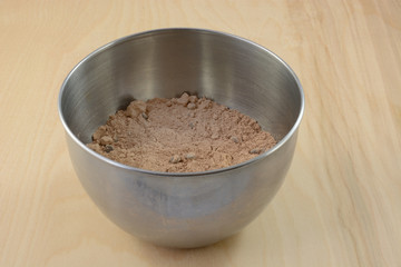 Chocolate cake or brownie with chocolate chips in stainless steel mixing bowl