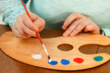 An artist mixing paints on the palette