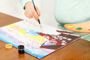 Woman's hand painting Japanese landscape