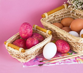 пасхальные яйца в корзинках на розовом фоне 