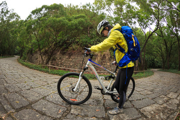 Obraz premium young woman riding mountain bike on forest trail