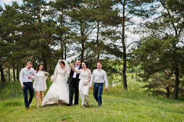 Funny and happy wedding couple with bridesmaids and best mans.