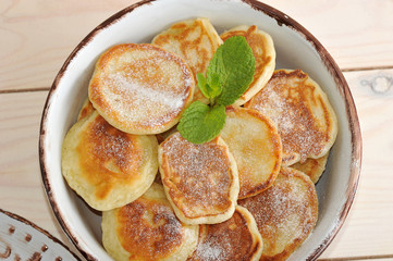 cheese pancakes with vanilla and mint leaves in bowl