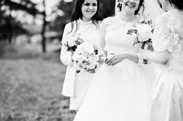 Pretty bride with bridesmaids on white dresses with bouquets on