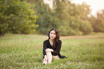 Pretty Thai girl sit down at the park