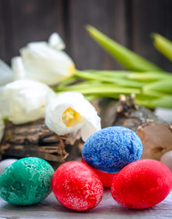 White tulips and colored Easter eggs