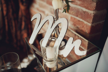 white candle in a transparent glass and white letters next to it