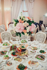 tasty snacks and salads stands at the wedding table in restauran