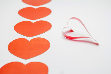 Paper and ribbon shaped as hearts on white background, valentine's day.