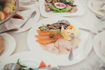 tasty snacks and salads stands at the wedding table in restauran