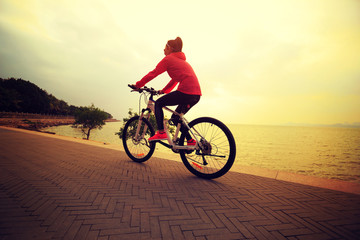 one young woman riding bike on seaside