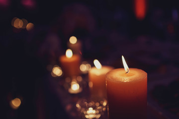 lighted round candles stand on the table in the dark
