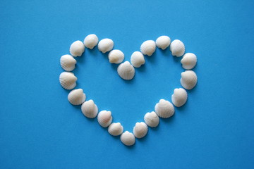 A heart from different seashells on the blue background for Valentine's Day.