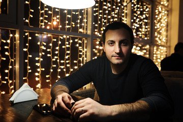 man holding glass of alcohol with ice in a night club